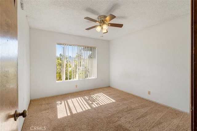 empty room with a textured ceiling, ceiling fan, and light colored carpet