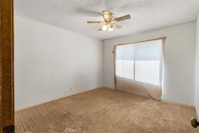 carpeted empty room with a ceiling fan and a textured ceiling