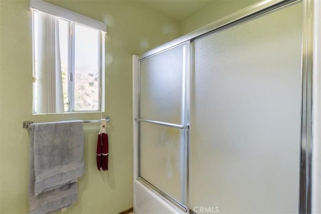 bathroom featuring bath / shower combo with glass door