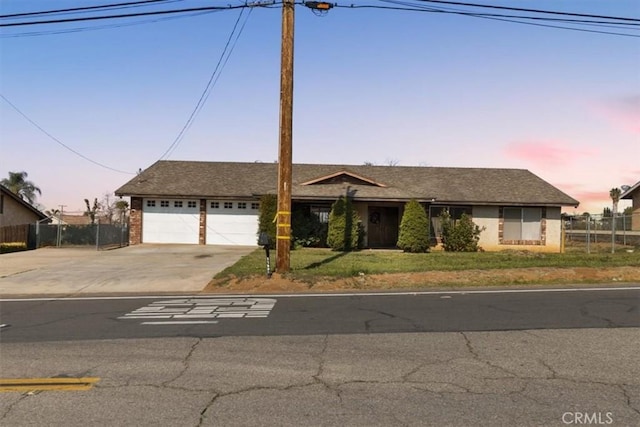 single story home featuring a garage, driveway, and fence