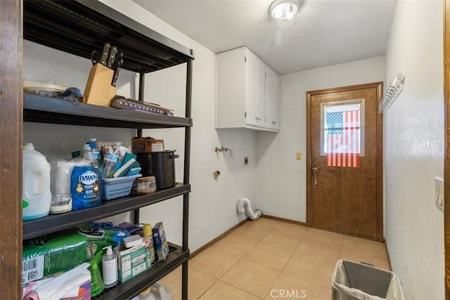 washroom featuring cabinet space, baseboards, and light tile patterned flooring