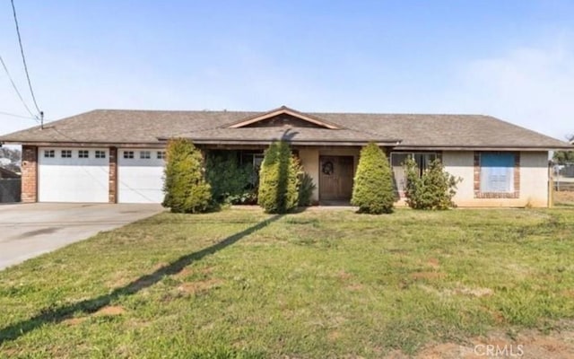 ranch-style house featuring a garage, a front lawn, and concrete driveway