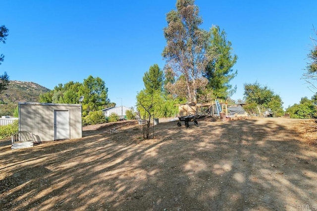 view of yard featuring a mountain view and a storage unit