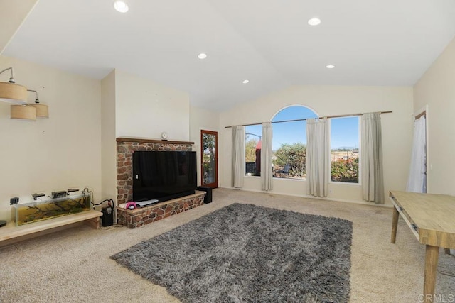 carpeted living room featuring a brick fireplace and lofted ceiling