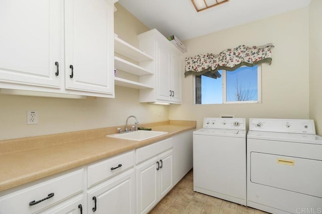 clothes washing area with sink, cabinets, and washer and dryer