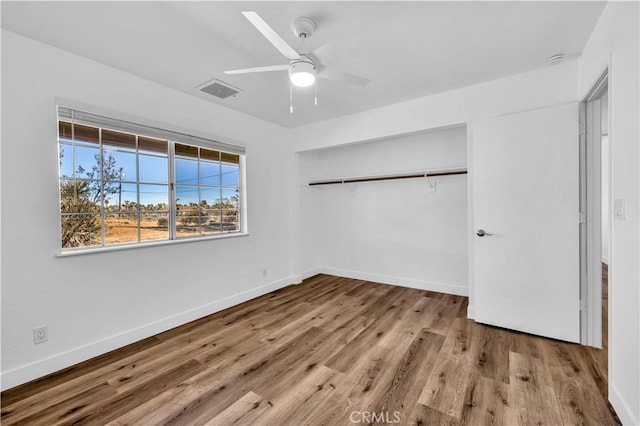 unfurnished bedroom featuring ceiling fan, light hardwood / wood-style floors, and a closet