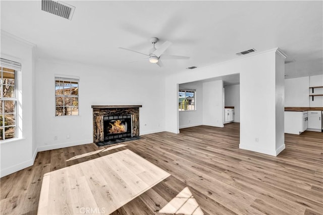 unfurnished living room with crown molding, light hardwood / wood-style floors, and ceiling fan