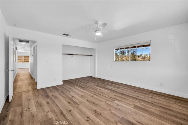 unfurnished bedroom featuring ceiling fan, light wood-type flooring, and a closet