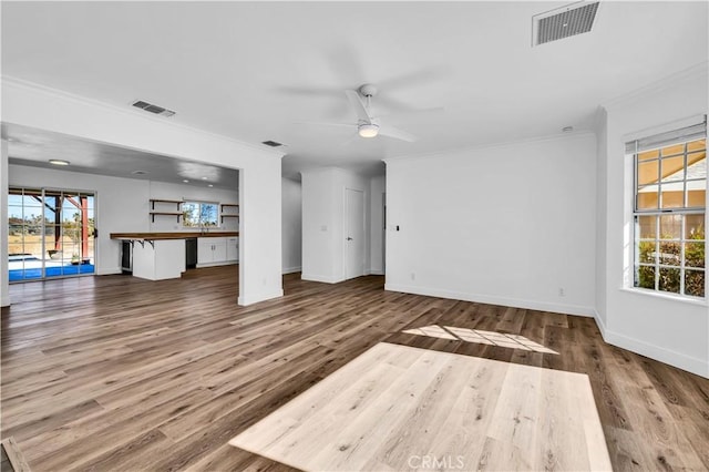 unfurnished living room featuring ceiling fan, ornamental molding, and hardwood / wood-style floors