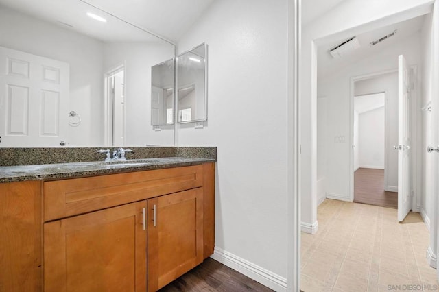 bathroom with vaulted ceiling and vanity