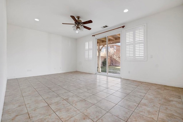 spare room featuring ceiling fan, light tile patterned flooring, and plenty of natural light