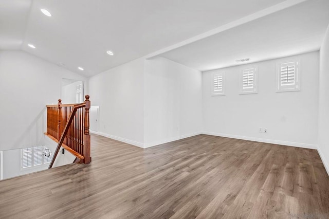 spare room featuring lofted ceiling and light wood-type flooring