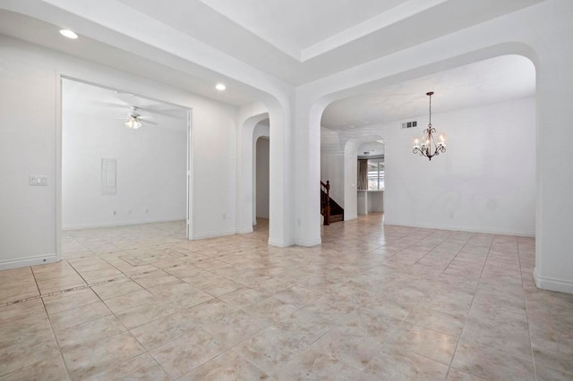 unfurnished room with ceiling fan with notable chandelier