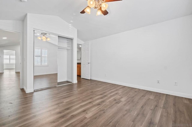 unfurnished bedroom featuring ceiling fan, a closet, lofted ceiling, and wood-type flooring