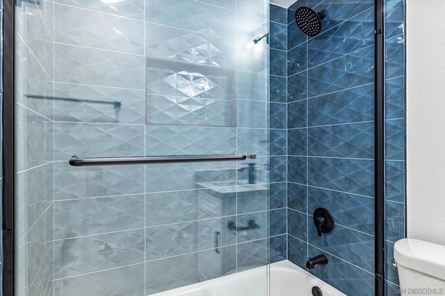 bathroom featuring toilet and tiled shower / bath