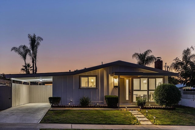 view of front of property featuring a lawn and a carport