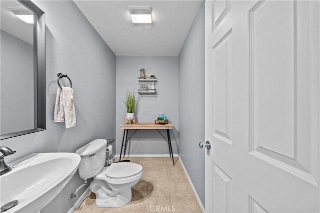 bathroom featuring sink, toilet, and tile patterned floors