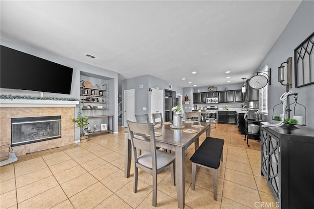 tiled dining space featuring a tiled fireplace and built in features