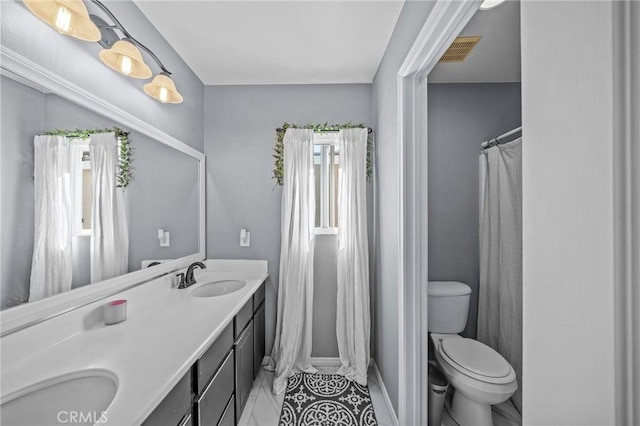 bathroom featuring toilet, tile patterned flooring, and vanity