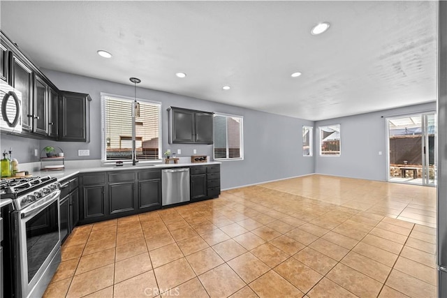 kitchen with appliances with stainless steel finishes, pendant lighting, sink, and light tile patterned floors