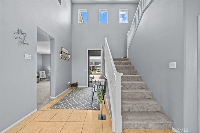 tiled foyer entrance with a towering ceiling