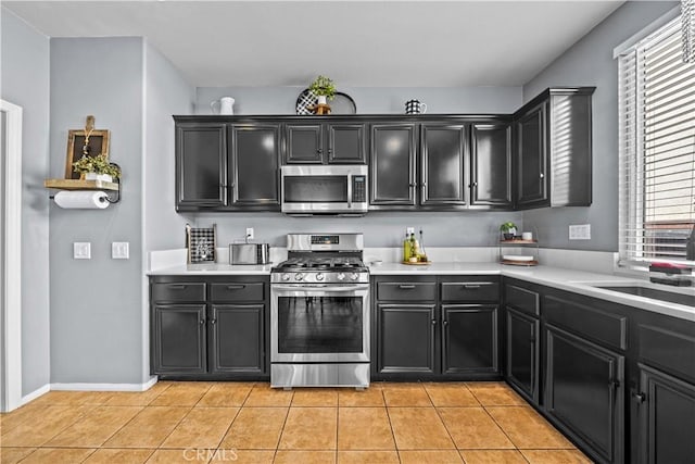 kitchen with stainless steel appliances, light tile patterned floors, and sink