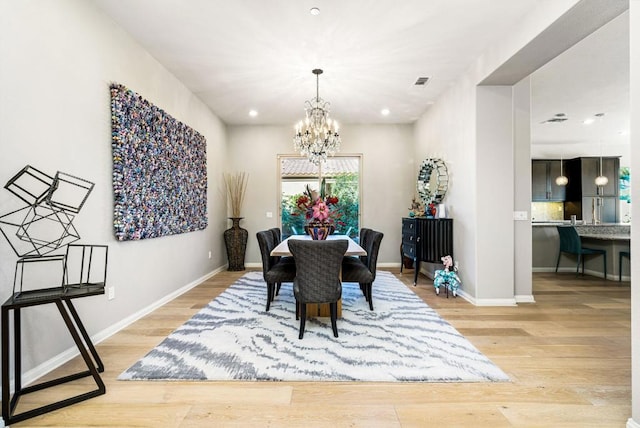 dining space with light wood-type flooring and a chandelier