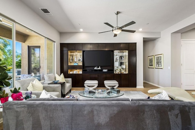 living room with light wood-type flooring and ceiling fan