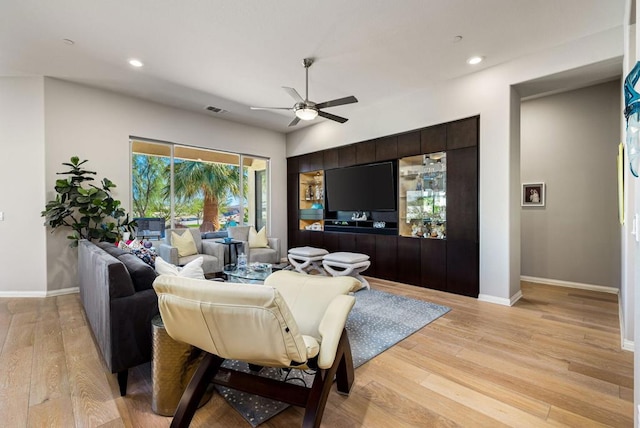 living room featuring ceiling fan and light hardwood / wood-style floors