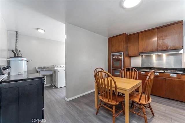 dining area featuring secured water heater, washer / dryer, and hardwood / wood-style floors