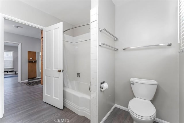 bathroom with bathtub / shower combination, toilet, and hardwood / wood-style floors