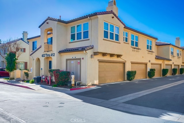 view of front of home with a garage and central AC unit