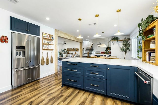 kitchen with hanging light fixtures, blue cabinets, high quality fridge, and dark wood-type flooring