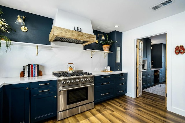 kitchen with dark wood-type flooring, premium range hood, blue cabinetry, and high end range