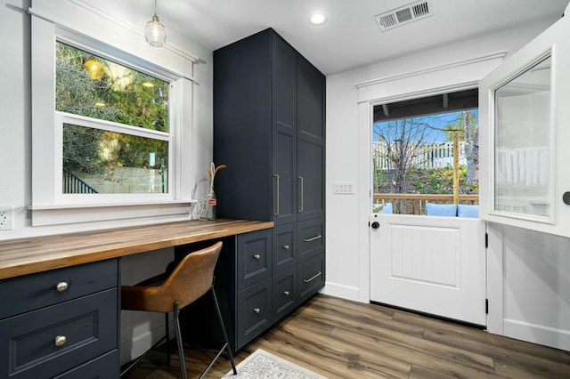 office area with dark wood-type flooring and built in desk