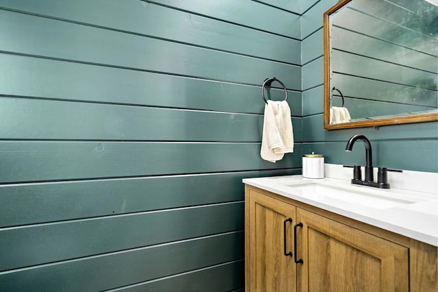 bathroom featuring wood walls and vanity