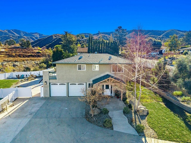 view of front of home with a garage and a mountain view