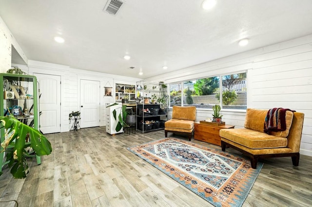 living area featuring hardwood / wood-style floors and wood walls