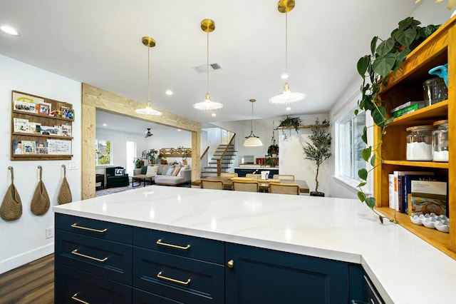 kitchen with blue cabinetry, hanging light fixtures, and dark wood-type flooring