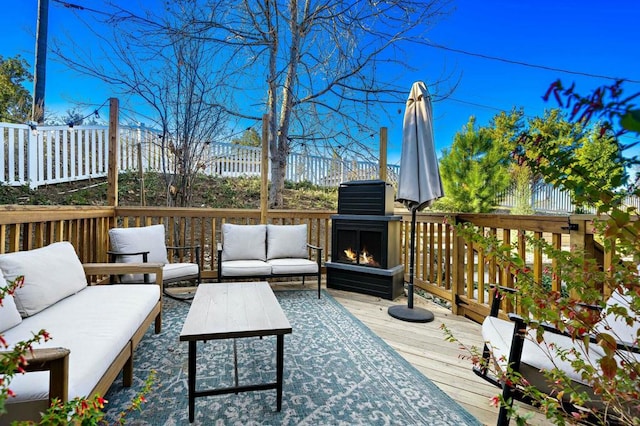 wooden deck with an outdoor living space with a fireplace