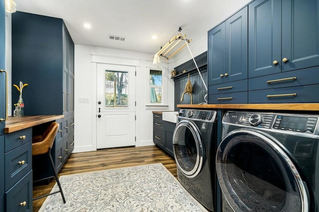 laundry area with sink, washing machine and dryer, cabinets, and dark hardwood / wood-style floors