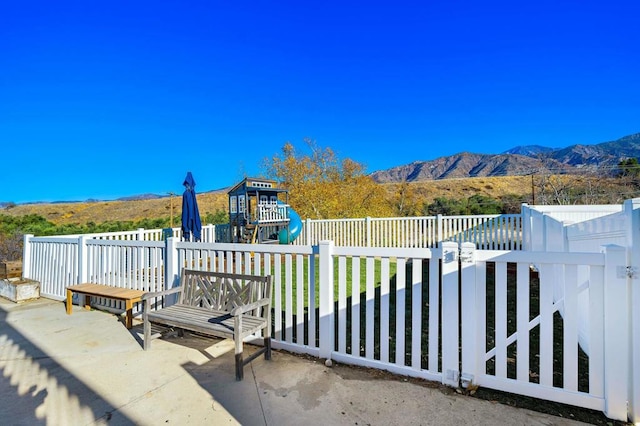 view of patio with a playground and a mountain view