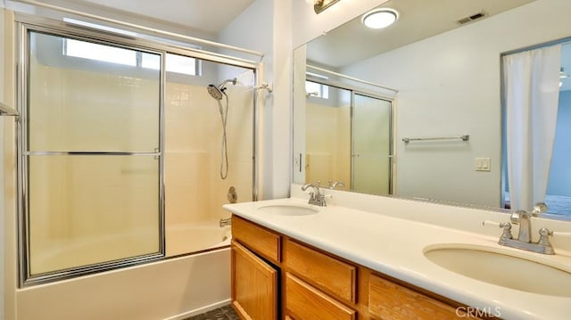 bathroom with combined bath / shower with glass door and vanity