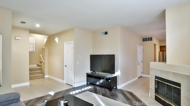 living room featuring light tile patterned flooring and a tiled fireplace