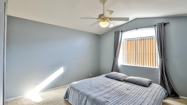 carpeted bedroom featuring ceiling fan, multiple windows, and lofted ceiling