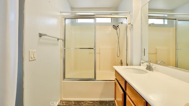 bathroom with plenty of natural light, combined bath / shower with glass door, and vanity