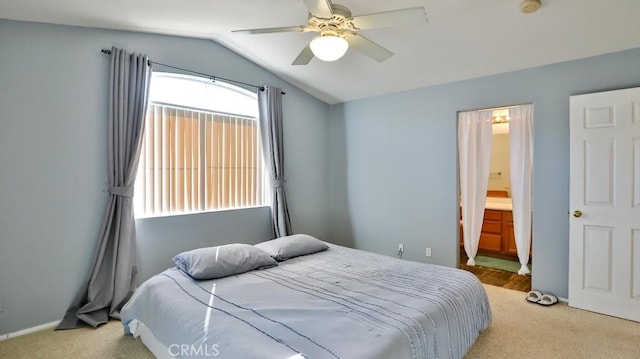 bedroom featuring ceiling fan, light colored carpet, ensuite bathroom, and lofted ceiling