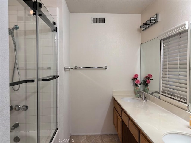1911 E Calico Dr, West Covina, CA 91791 - full bath with double vanity, bath / shower combo with glass door, and baseboards