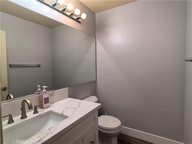 1911 E Calico Dr, West Covina, CA 91791 - half bathroom with wood finished floors, toilet, baseboards, and vanity