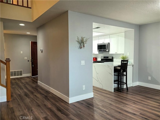 1911 E Calico Dr, West Covina, CA 91791 - kitchen with appliances with stainless steel finishes, dark wood-style flooring, white cabinets, baseboards, and recessed lighting